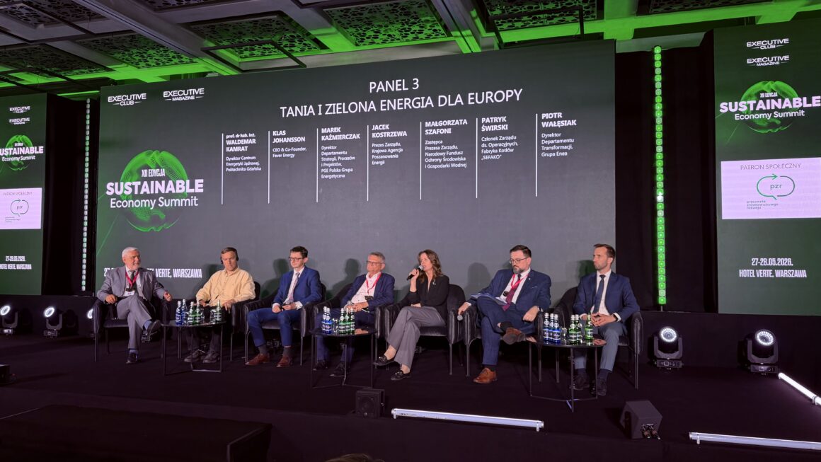 Panel dyskusyjny „Tania i zielona energia dla Europy” podczas Sustainable Economy Summit w Warszawie. Na scenie siedzi siedmioro ekspertów i ekspertek rozmawiających o transformacji energetycznej oraz przyszłości zielonej energii. Jedna z uczestniczek trzyma mikrofon i zabiera głos. W tle widoczny jest duży ekran z nazwą panelu, listą panelistów oraz logotypami wydarzenia i Pracowni Zrównoważonego Rozwoju jako patrona społecznego.