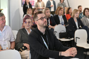 Uczestnicy siedzą na sali i słuchają prelekcji podczas forum w Gdańsku.