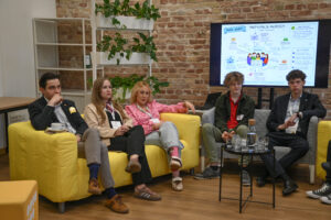 Panel dyskusyjny z udziałem młodych osób siedzących na kanapach i rozmawiających o partycypacji młodzieży.
